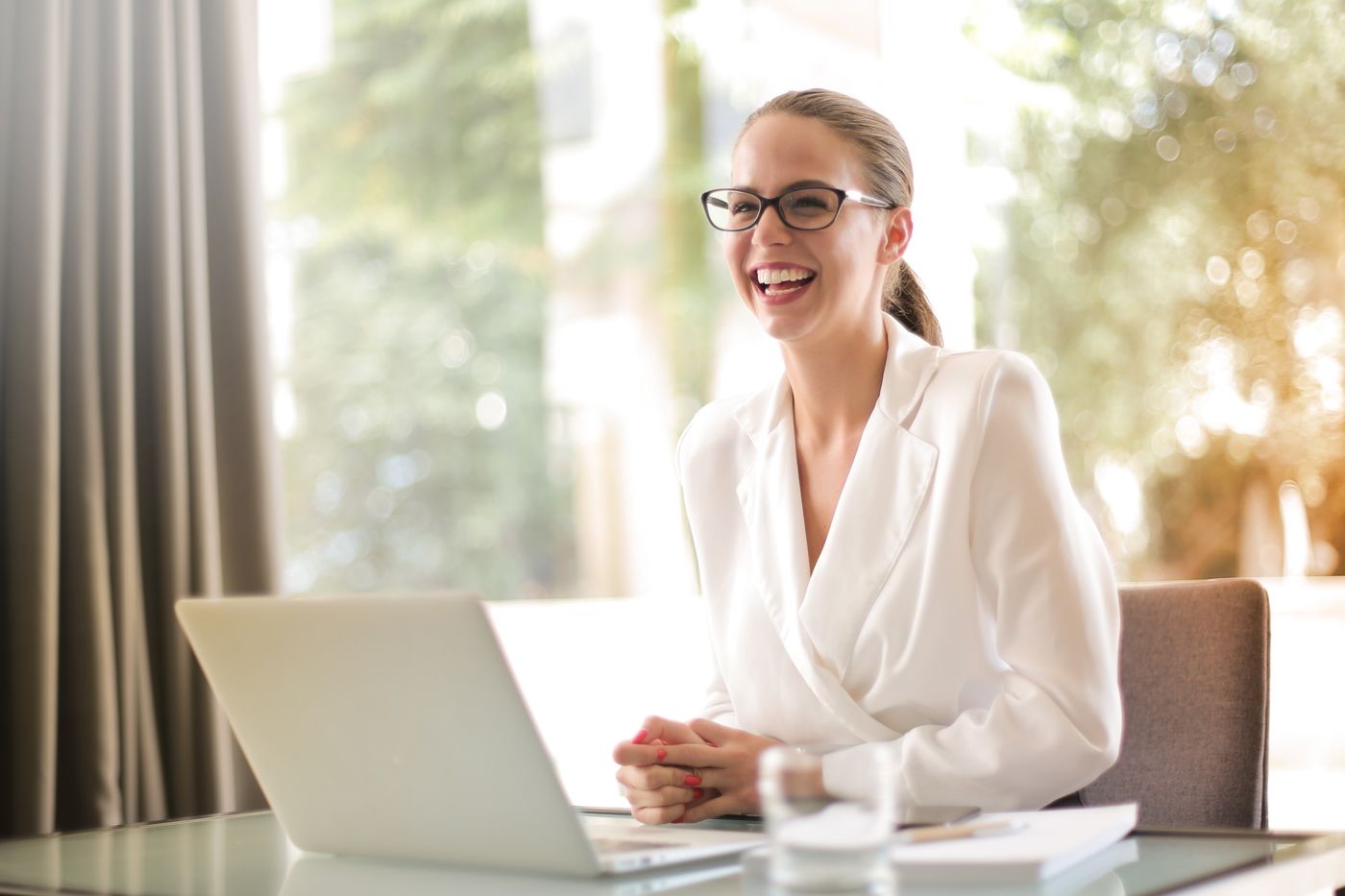 A client smiling at her laptop in a bright office