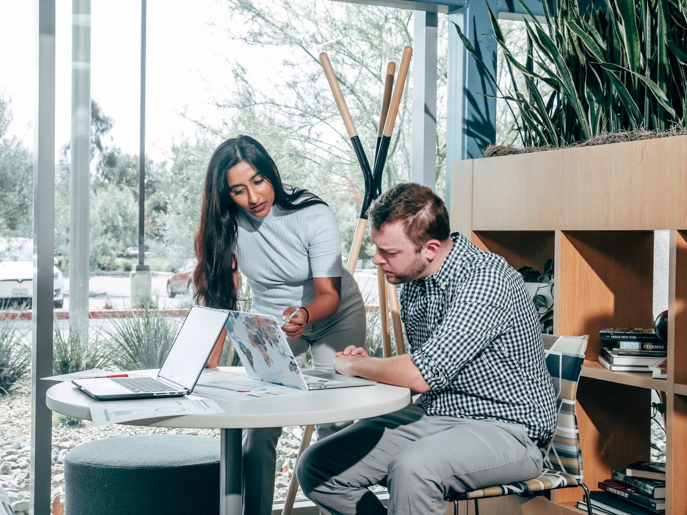 Two colleagues planning pages at a laptop